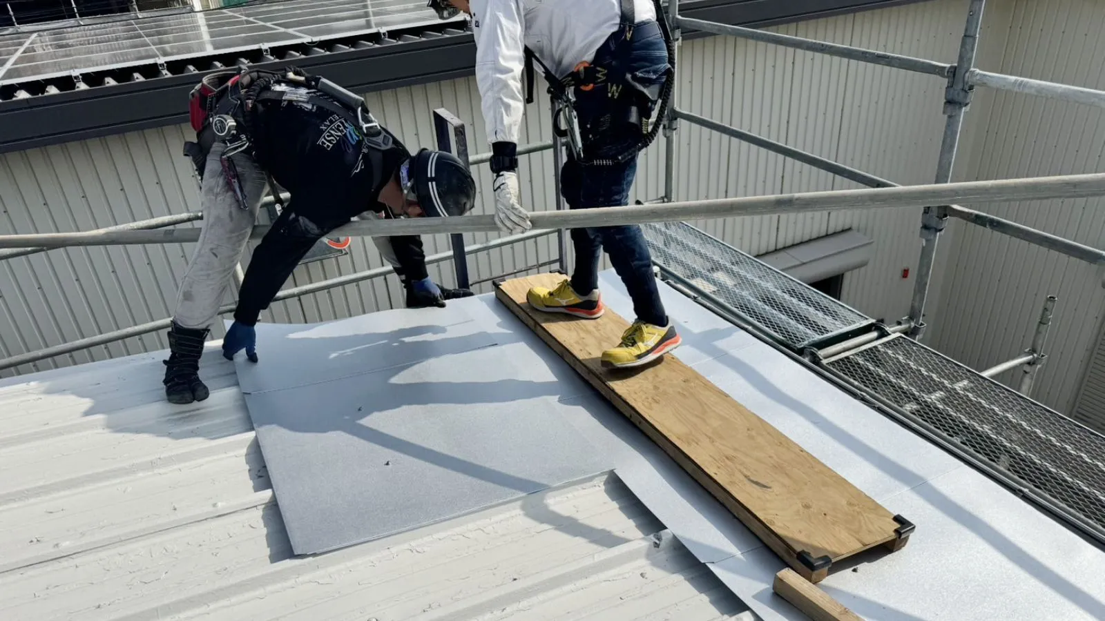 安城建築のトップヒートバリアーを施工している作業員が二人いる
